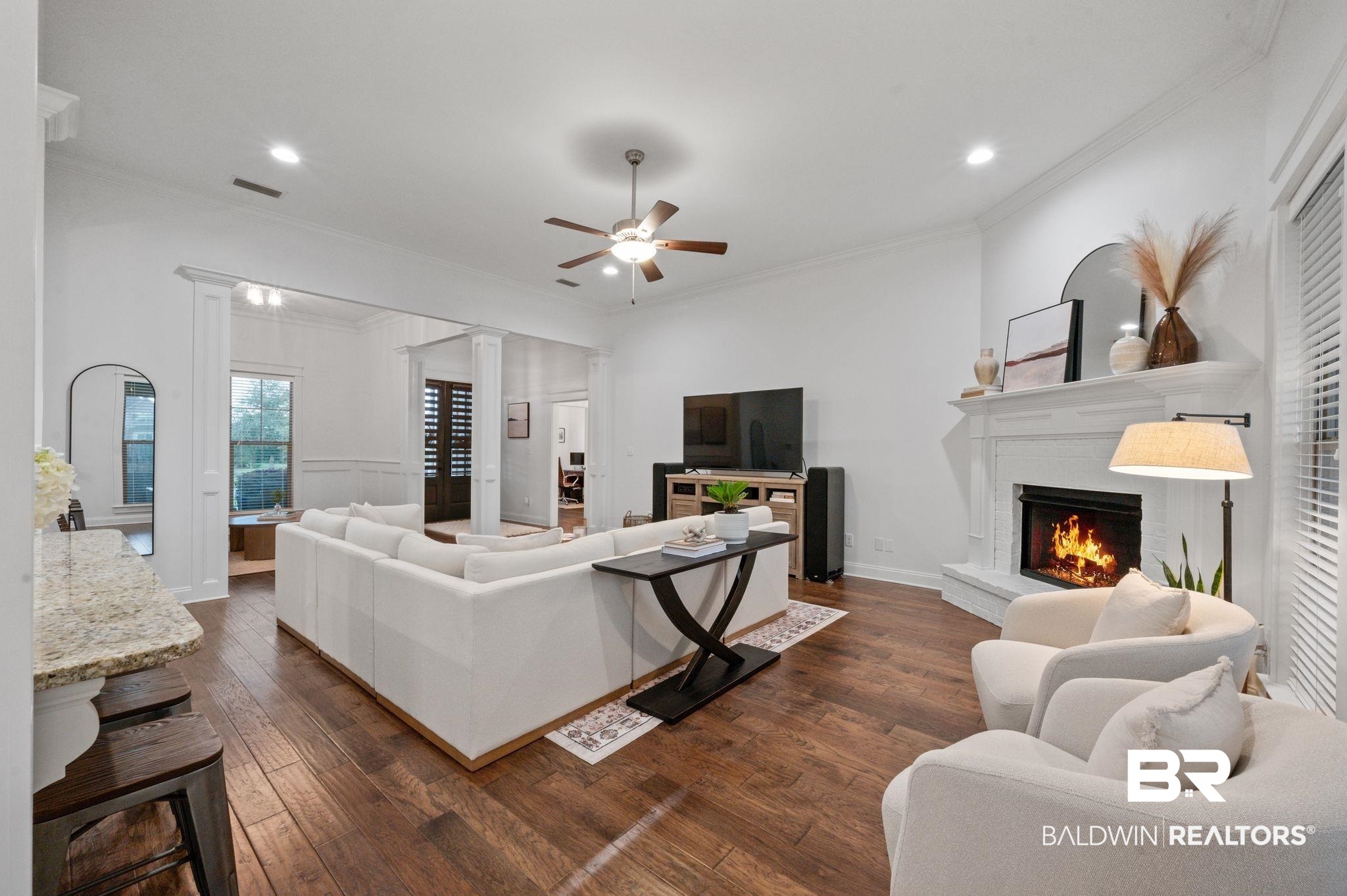 418 Fortune Drive Fairhope, AL 36532 - Photo 7 of 63 Living room featuring ceiling fan, dark hardwood / wood-style floors, a brick fireplace, and ornamental molding