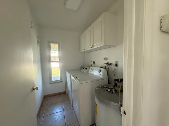 a utility room with cabinets washer and dryer