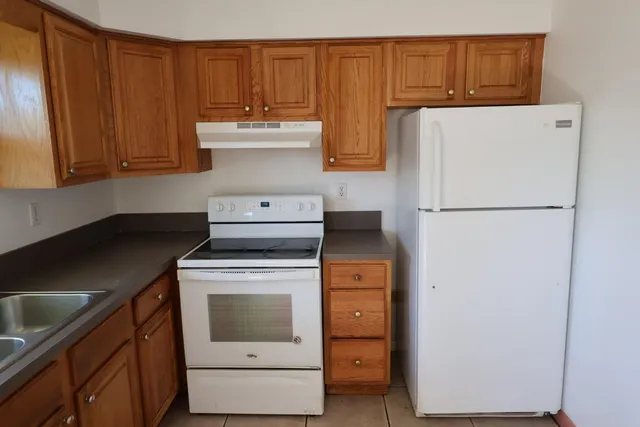 a kitchen with a refrigerator sink and cabinets