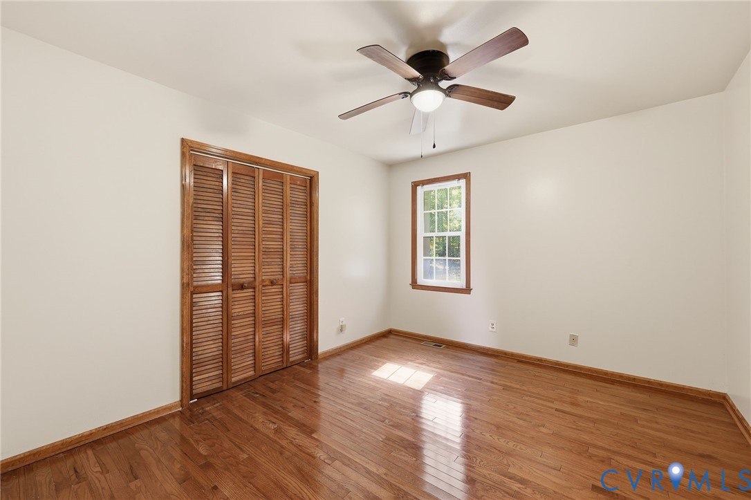 2521 Fort Lee Road Petersburg, VA 23805 - Photo 14 of 27 an empty room with wooden floor chandelier fan and windows