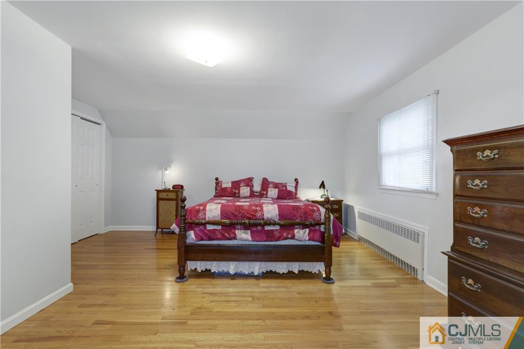 73 Ramsey Road Middlesex, NJ 08846 - Photo 20 of 25 a bedroom with a bed and a lamp with wooden floor