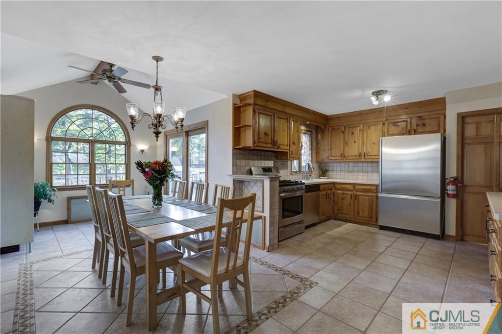 73 Ramsey Road Middlesex, NJ 08846 - Photo 10 of 25 a kitchen with stainless steel appliances granite countertop a refrigerator a sink a stove a dining table and chairs