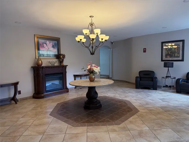 a living room with fireplace furniture a chandelier and a mirror