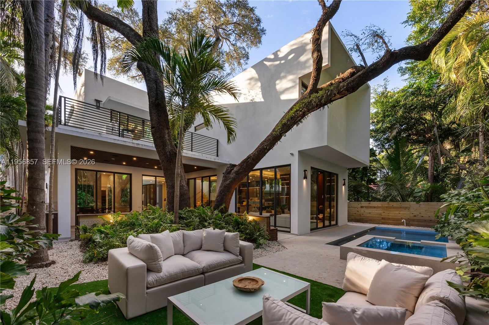 2805 Freeman Street Miami, FL 33133 - Photo 18 of 92 a view of a patio with couches table and chairs with wooden fence and plants