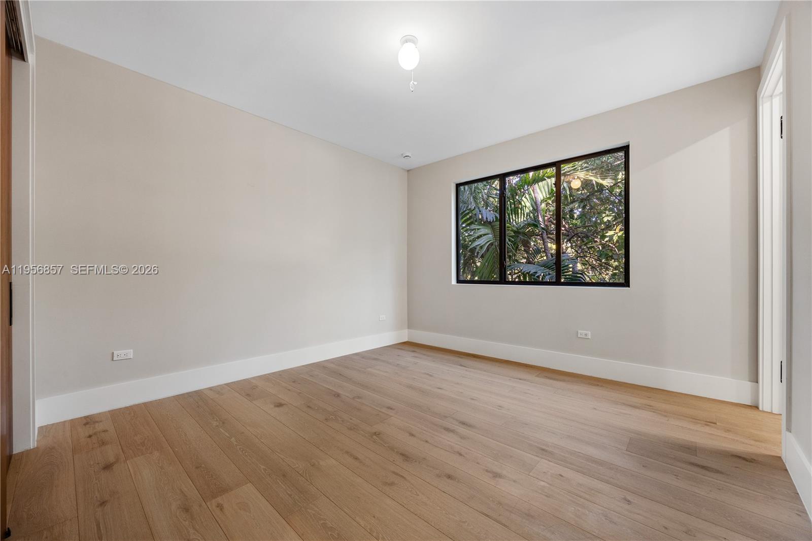2805 Freeman Street Miami, FL 33133 - Photo 48 of 92 an empty room with wooden floor and windows