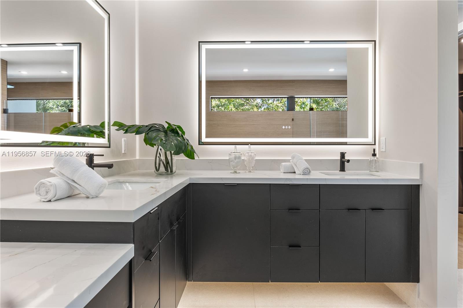 2805 Freeman Street Miami, FL 33133 - Photo 49 of 92 a bathroom with a granite countertop sink a large mirror a window and a bathtub