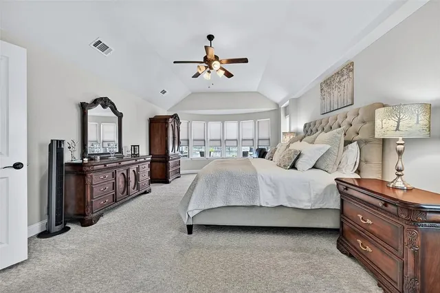 a spacious bedroom with a bed and dresser