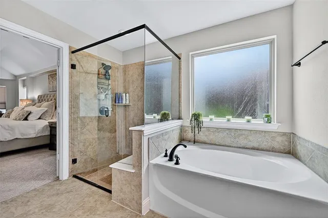 a bathroom with a tub a sink and a glass door shower