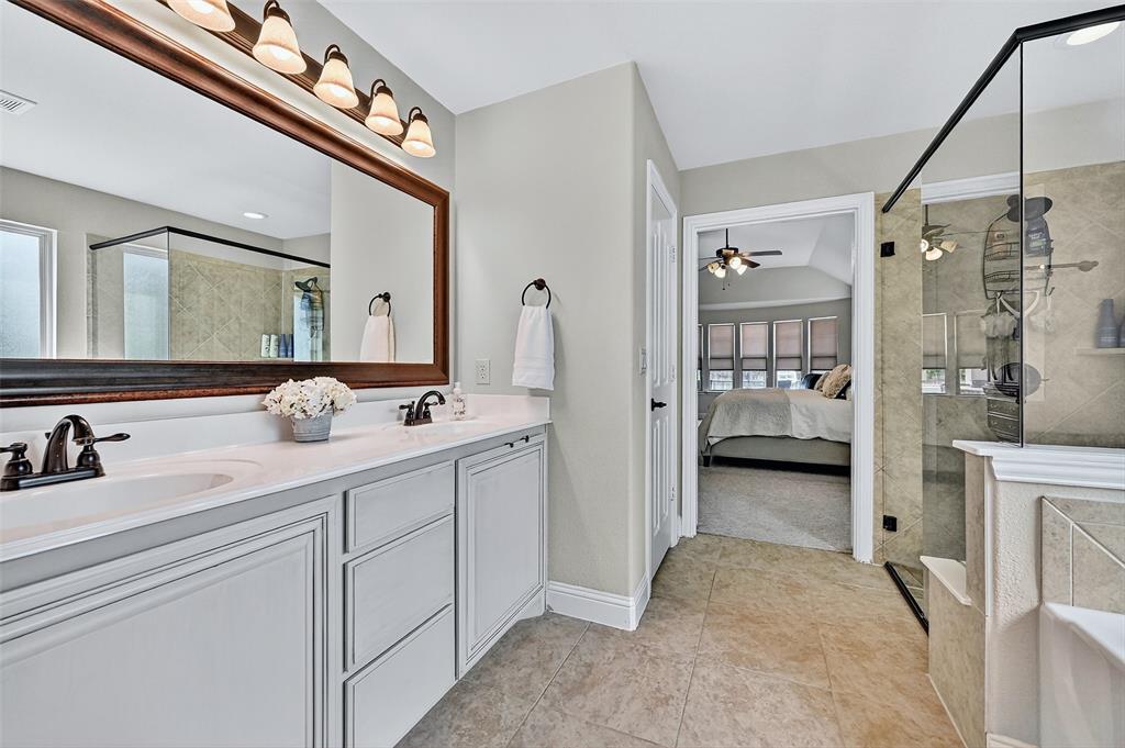 910 Calder Court Anna, TX 75409 - Photo 28 of 37 a en suite bathroom with a double vanity sink a mirror and shower