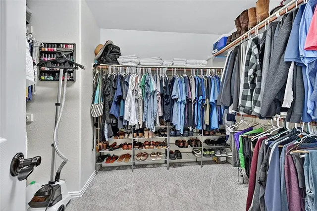 a view of walk in closet with clothes and shoes