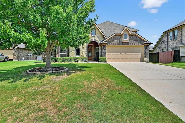 a front view of a house with a yard and trees