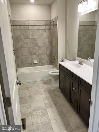 a bathroom with a granite countertop sink a toilet and shower