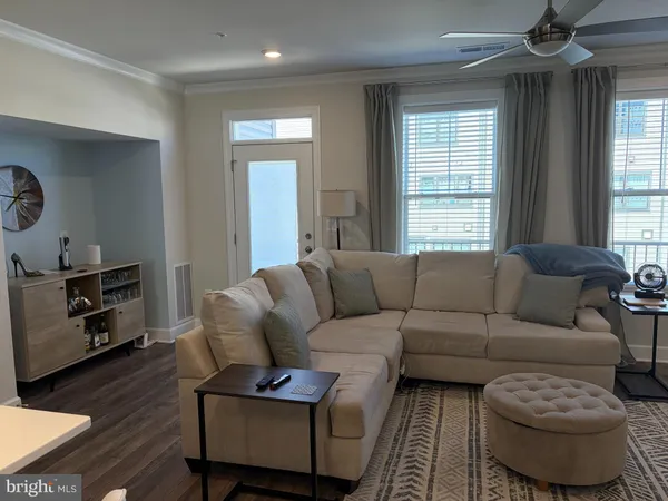 a living room with furniture a window and wooden floor