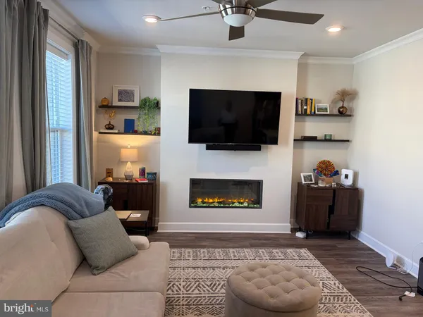 a living room with furniture a flat screen tv and a fireplace