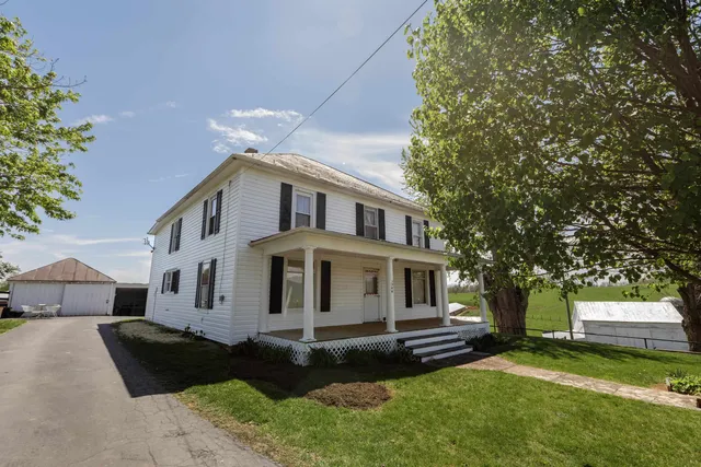 a view of a livingroom with furniture a chandelier and wooden floor