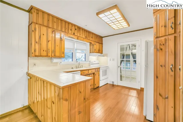 a view of a big room with windows and chandelier fan