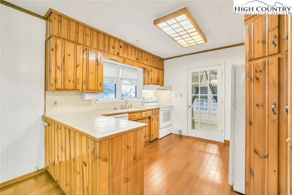 a kitchen with stainless steel appliances granite countertop a sink and cabinets with wooden floor
