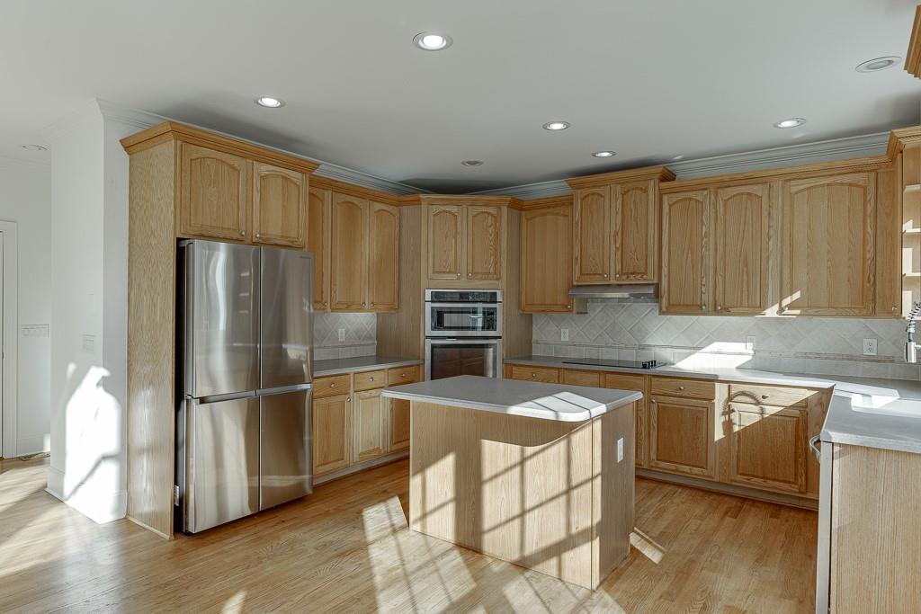 2747 Pathview Drive Dacula, GA 30019 - Photo 14 of 59 a kitchen with granite countertop a refrigerator stove top oven and wooden floor