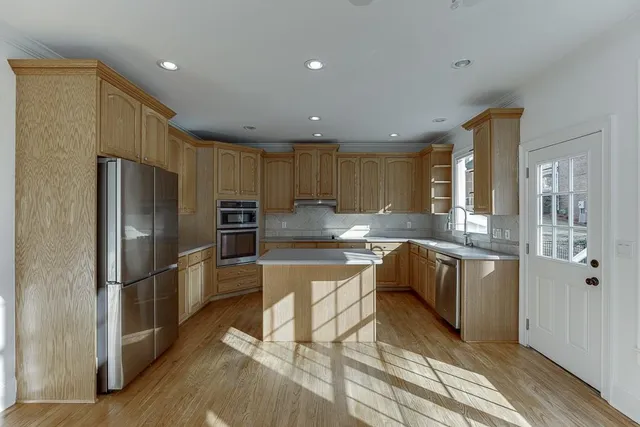 a kitchen with stainless steel appliances granite countertop a refrigerator and a stove top oven