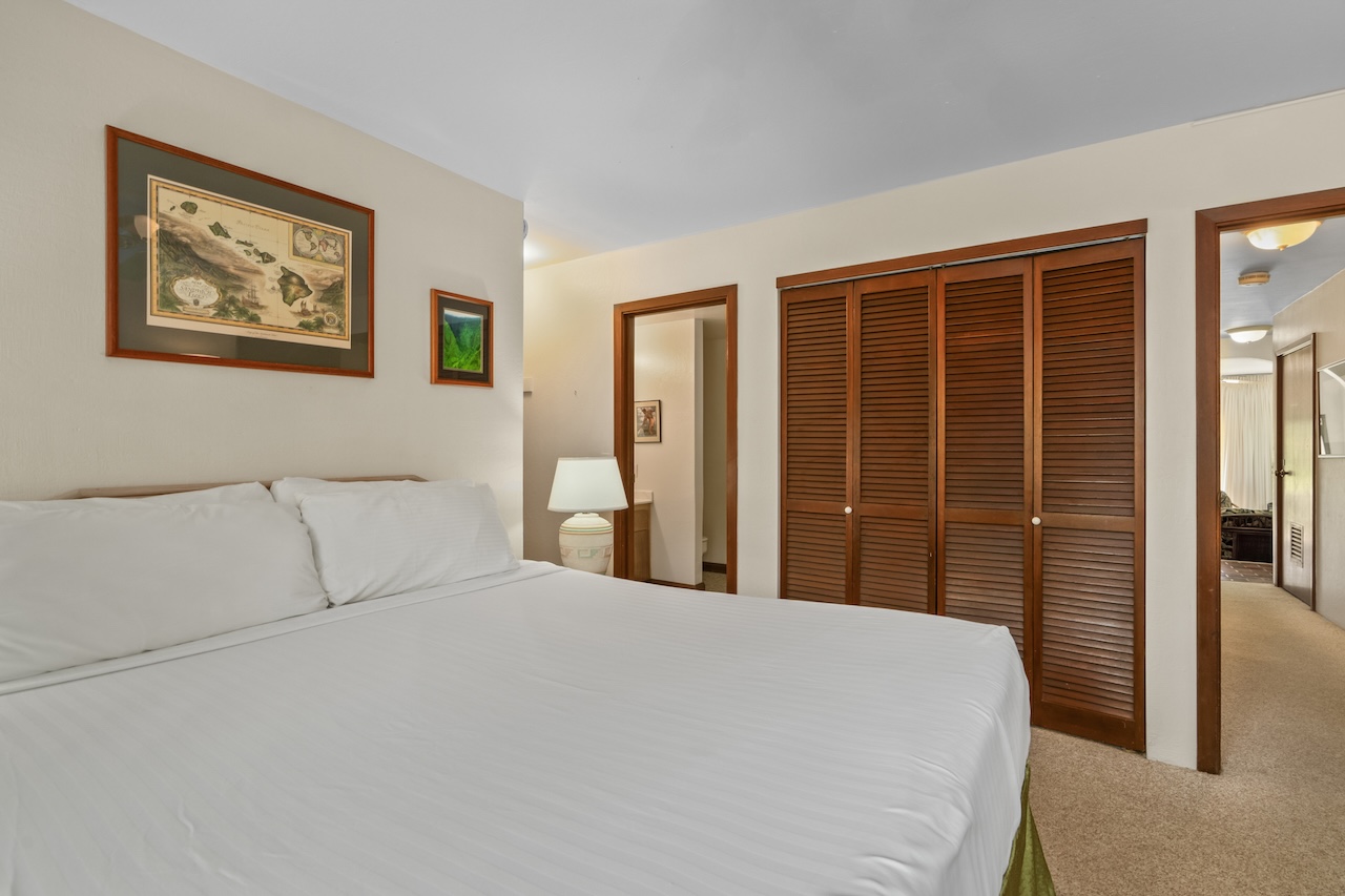 1901 Poipu Road, Unit 411 Koloa, HI 96756 - Photo 12 of 28 a bedroom with a large bed and a chandelier