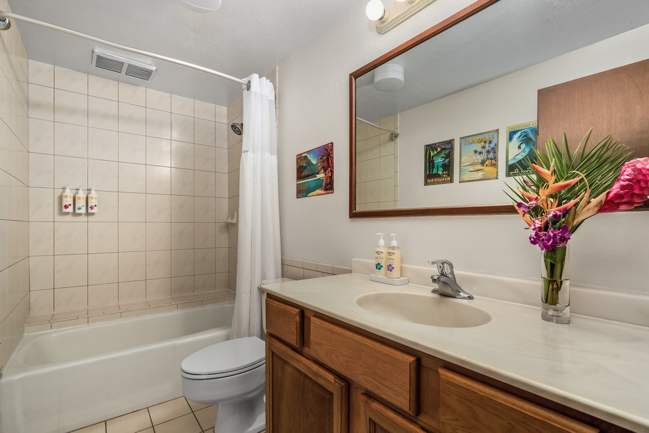 1901 Poipu Road, Unit 411 Koloa, HI 96756 - Photo 18 of 28 a bathroom with a sink a toilet a shower a mirror and bathtub