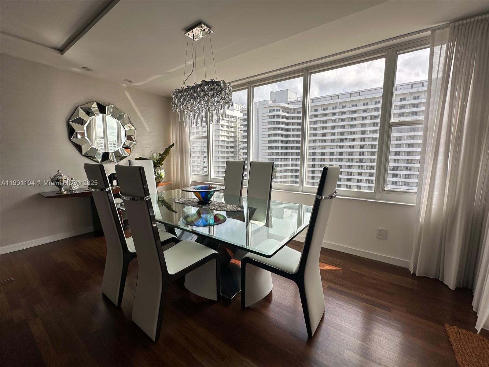 5600 Collins Avenue, Unit 9E Miami Beach, FL 33140 - Photo 11 of 55 a view of a dining room with furniture window and wooden floor