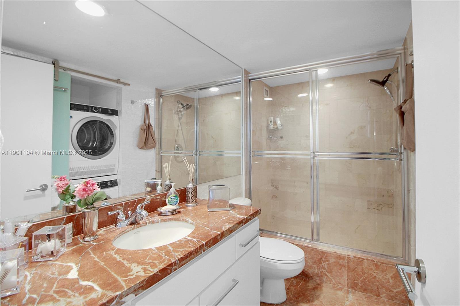 5600 Collins Avenue, Unit 9E Miami Beach, FL 33140 - Photo 29 of 55 a bathroom with a granite countertop sink toilet a mirror and shower