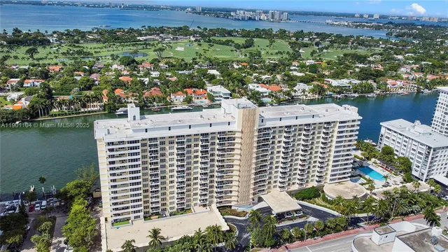 an aerial view of residential houses with outdoor space and lake view