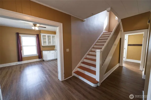 a view of a hallway with wooden floor and stairs