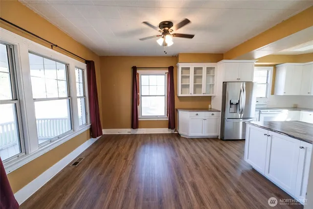 a view of an empty room with a kitchen and a window