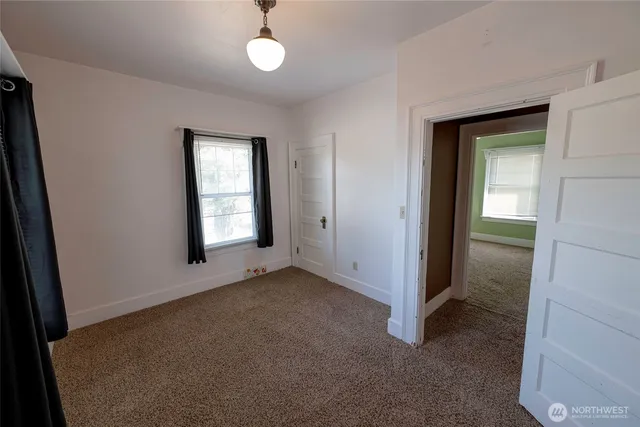 an empty room with windows and closet