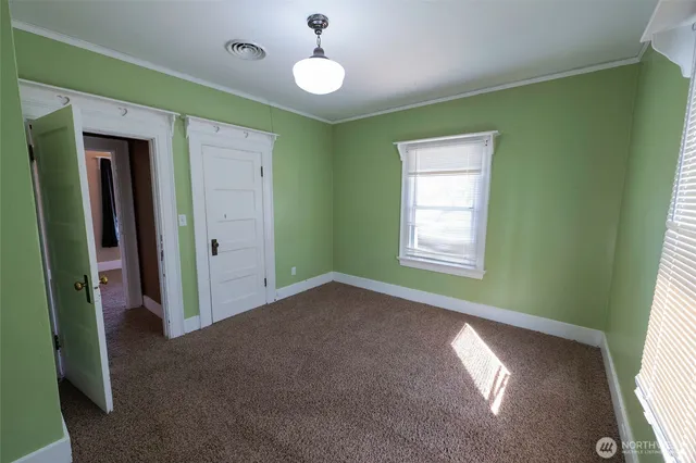 a view of empty room with window and ceiling fan