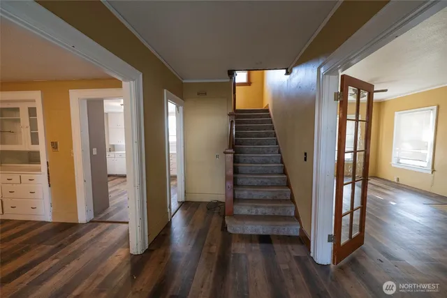 a view of a hallway with wooden floor and stairs