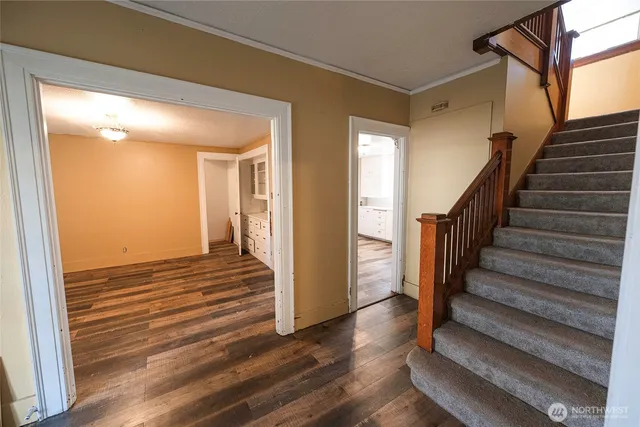 a view of a hallway with wooden floor and staircase