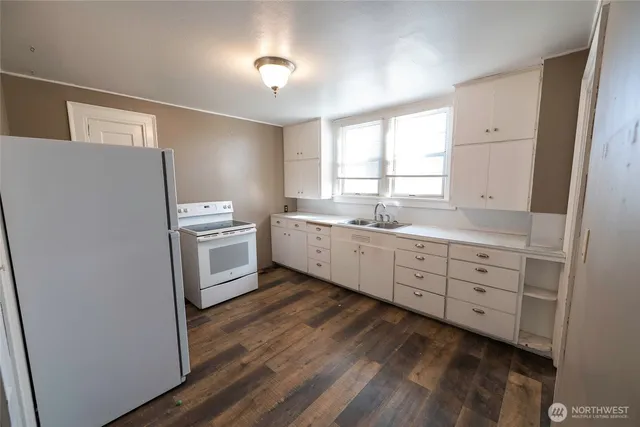 a kitchen with white cabinets and white appliances