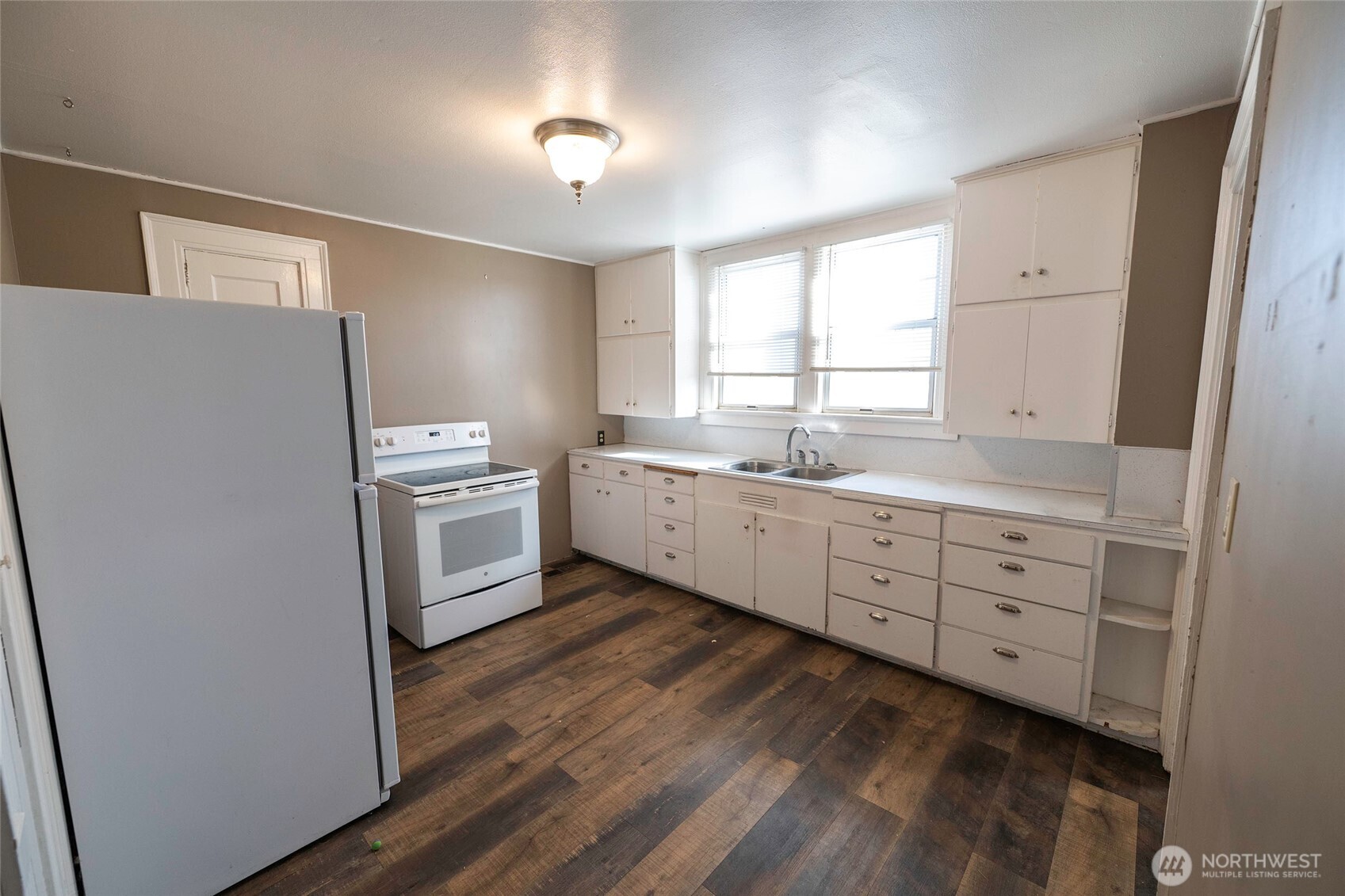 202 West 1st Street Prescott, WA 99348 - Photo 39 of 40 a kitchen with white cabinets and white appliances
