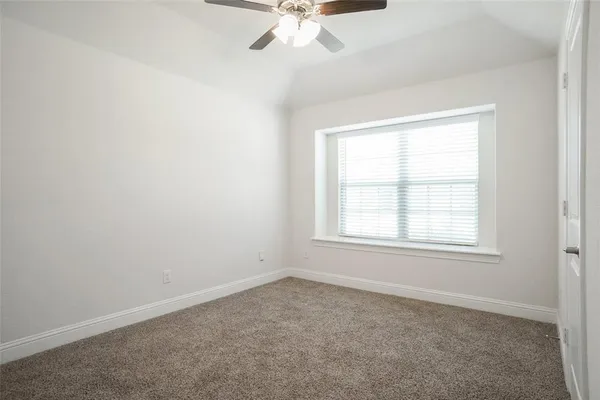 an empty room with a window and a fan