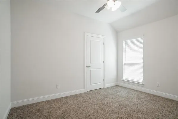 an empty room with a window and a ceiling fan