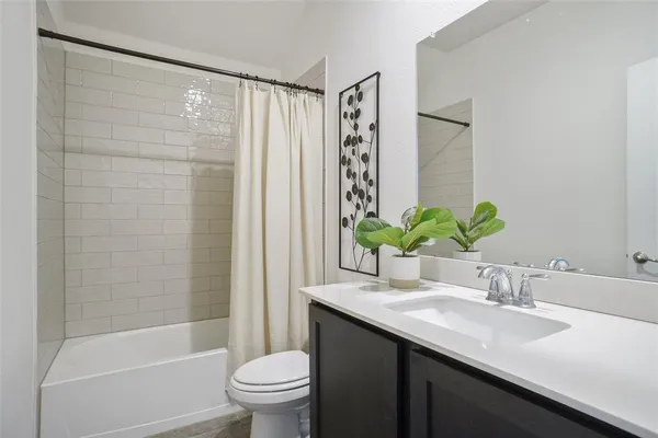 a bathroom with a granite countertop sink a toilet and shower