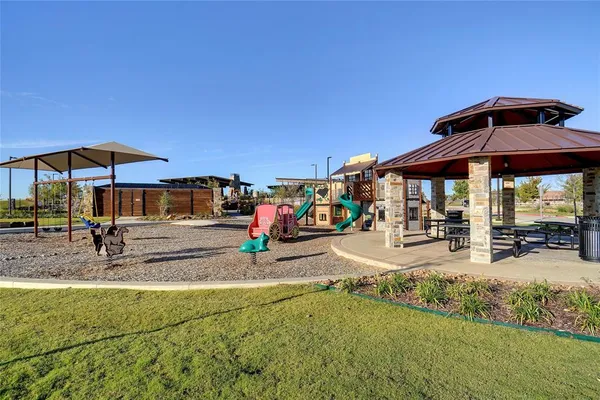 a view of a patio with a table and chairs under an umbrella