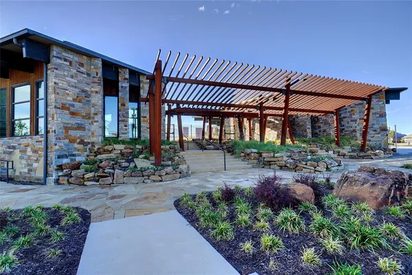 a view of a patio with table and chairs with plants and wooden fence