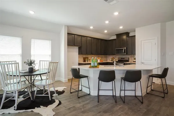 a living room with stainless steel appliances kitchen island granite countertop furniture and a large window