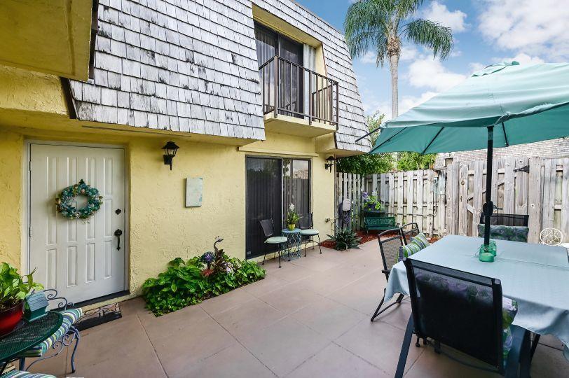 126 Woodland Road Palm Springs, FL 33461 - Photo 18 of 19 a view of a patio with table and chairs under an umbrella