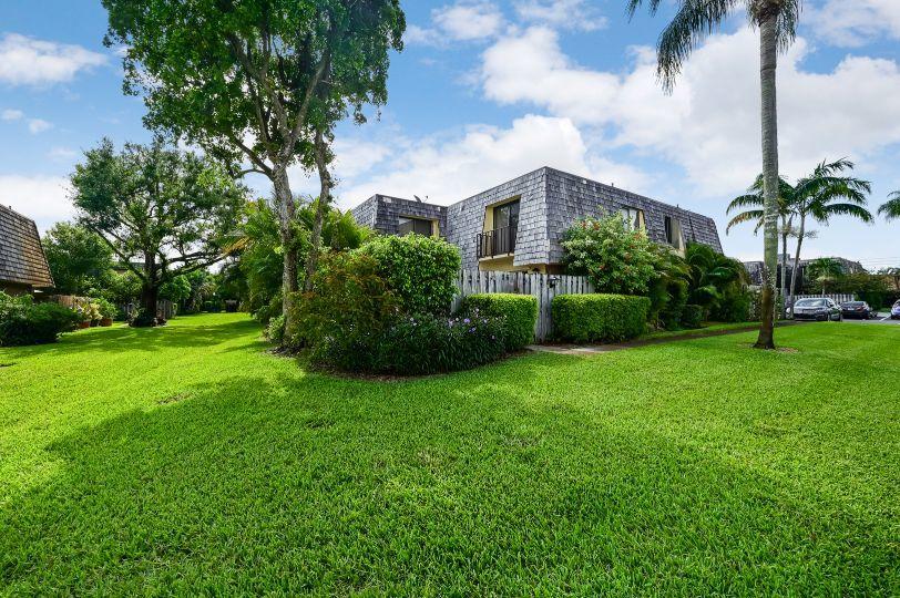 126 Woodland Road Palm Springs, FL 33461 - Photo 19 of 19 a view of a garden with a building in the background