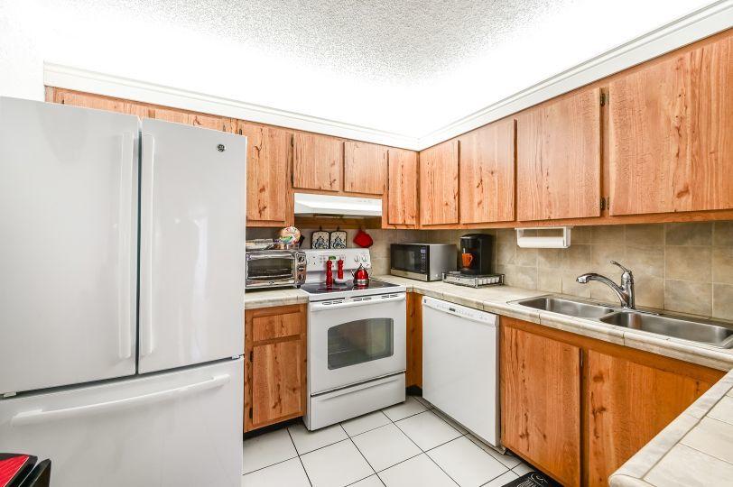 126 Woodland Road Palm Springs, FL 33461 - Photo 8 of 19 a kitchen with stainless steel appliances granite countertop a refrigerator sink and cabinets