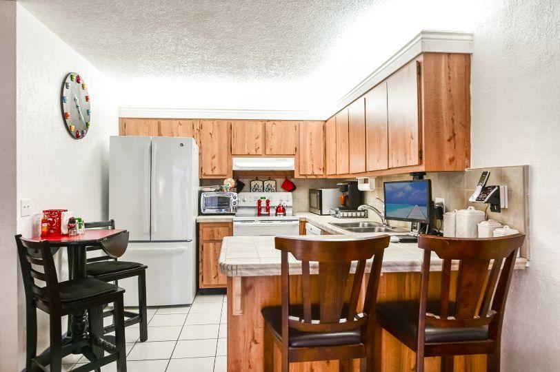 126 Woodland Road Palm Springs, FL 33461 - Photo 9 of 19 a kitchen with a dining table chairs and a refrigerator