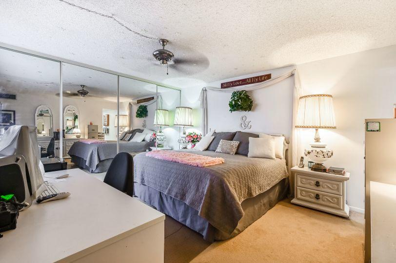 126 Woodland Road Palm Springs, FL 33461 - Photo 10 of 19 a spacious bedroom with a bed a couch and dresser