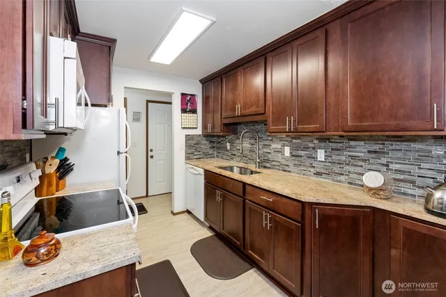 a kitchen with stainless steel appliances granite countertop wooden cabinets a sink and dishwasher