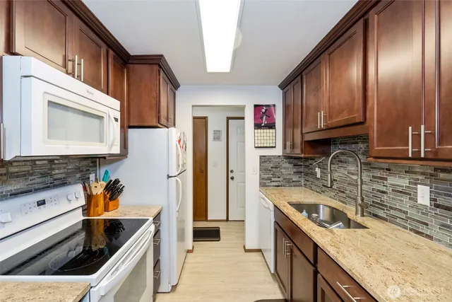 a kitchen with stainless steel appliances granite countertop a sink stove and refrigerator