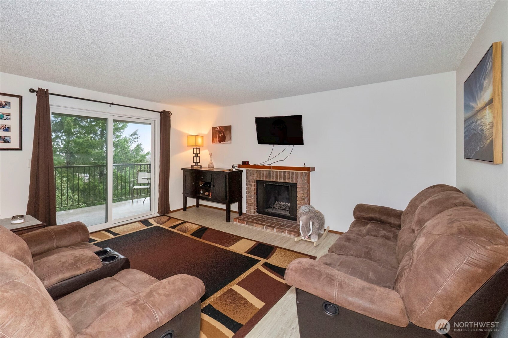 3400 Narrows View Lane Northeast, Unit 204 Bremerton, WA 98310 - Photo 5 of 38 a living room with furniture a flat screen tv and a fireplace